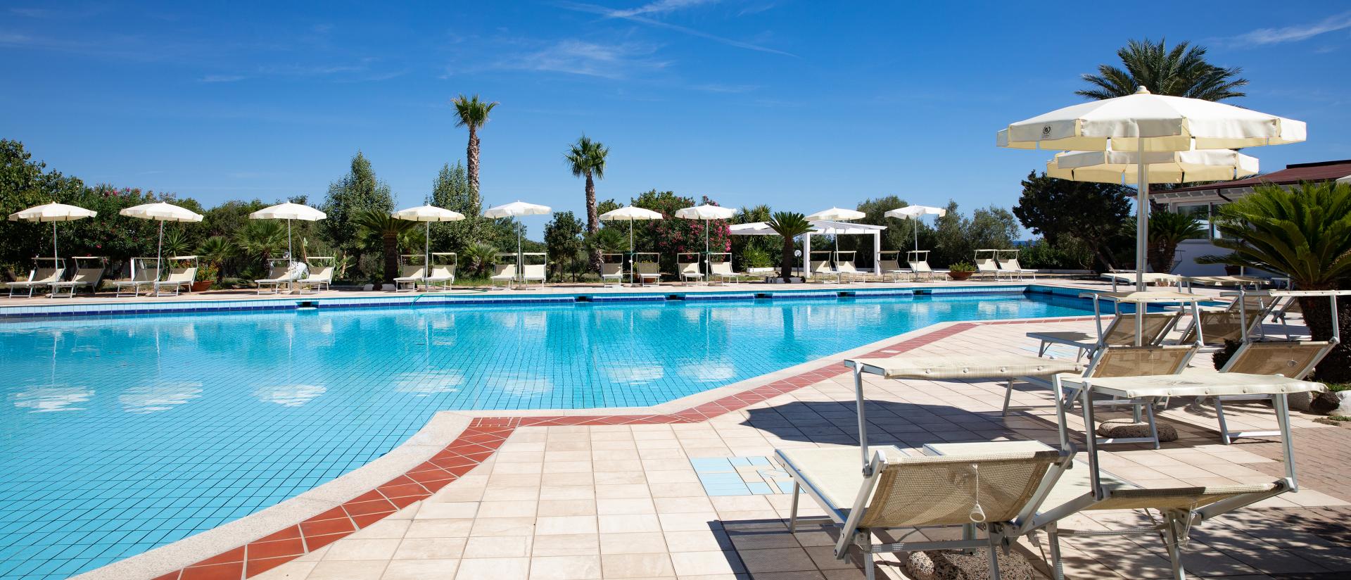Buitenzwembad met ligbedden — Nicolaus Club Quattro Lune Resort