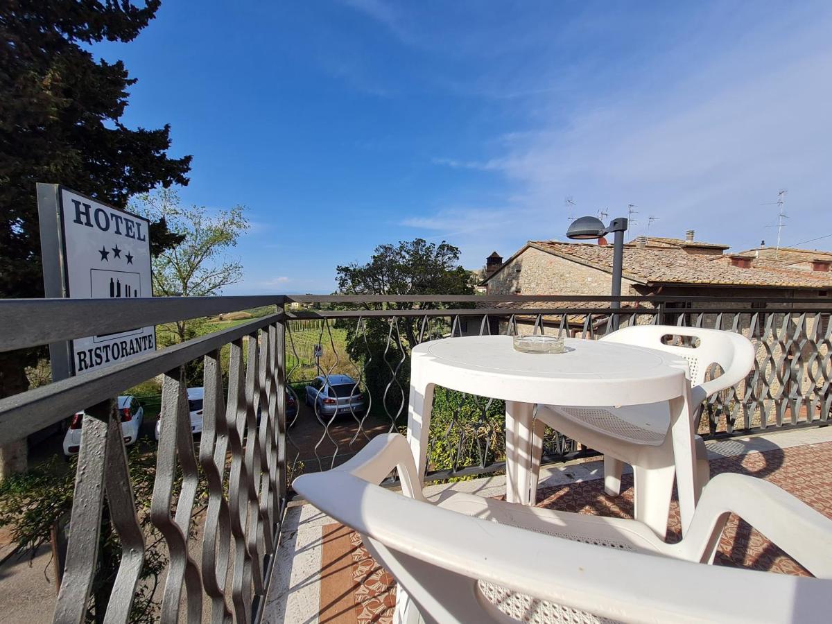 een witte tafel en stoelen op een balkon bij Hotel Da Graziano in San Gimignano