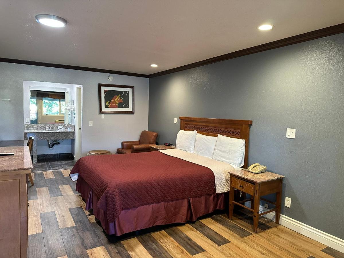 een hotelkamer met een bed en een bureau bij Corona inn in Corona