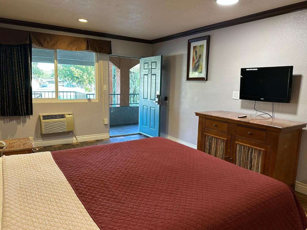 een slaapkamer met een bed en een flatscreen-tv bij Corona inn in Corona