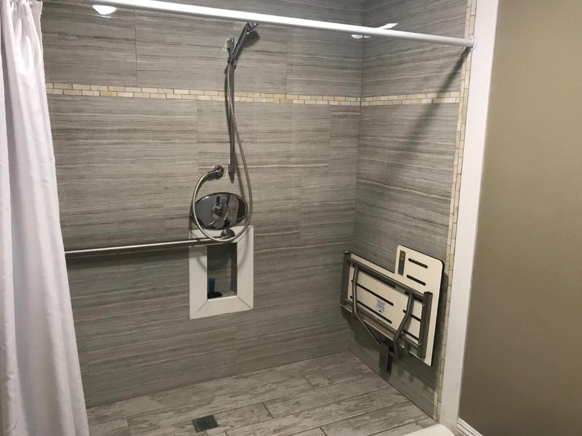 een douche in een badkamer met een houten wand bij Corona inn in Corona