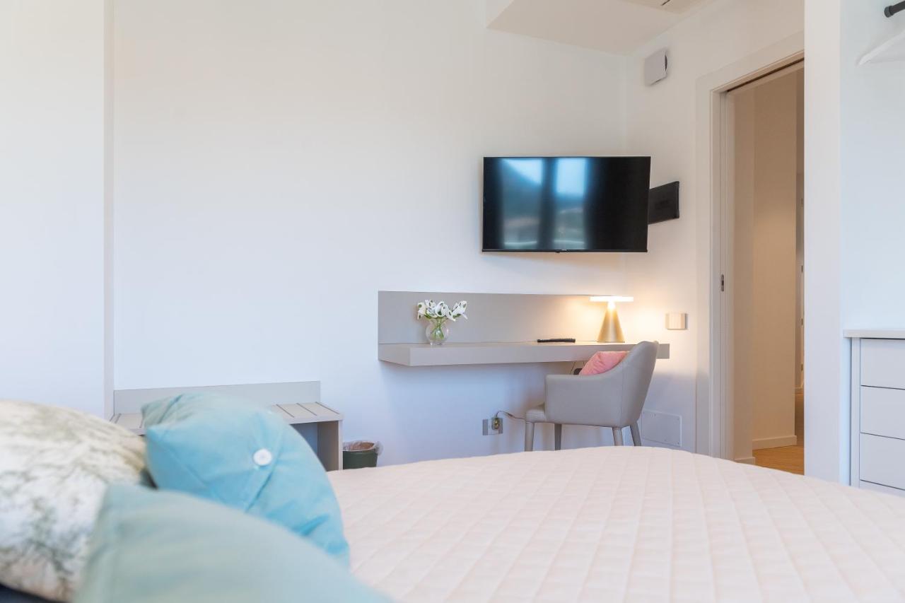 een slaapkamer met een bed en een televisie aan de muur bij Camere in villa da Anna, Poggio dei Pini in Poggio Dei Pini