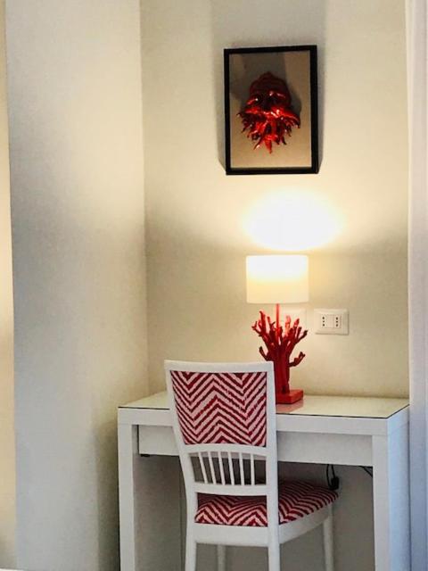 een wit bureau met een stoel en een lamp erop. bij Sorrento ResArt Suite in Sorrento