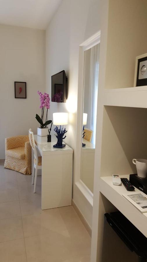 een witte woonkamer met een tafel en een lamp bij Sorrento ResArt Suite in Sorrento