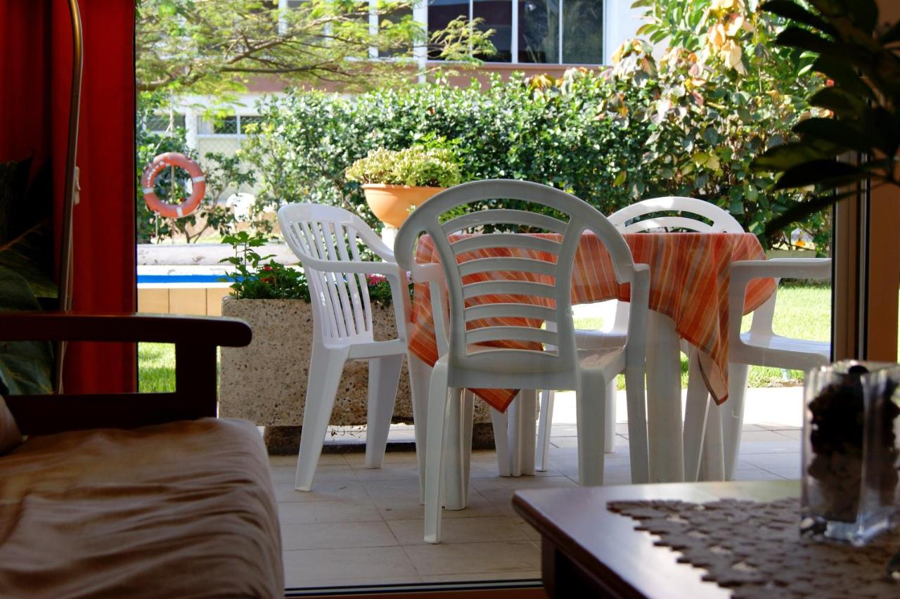 vier witte stoelen en een tafel op een terras bij Apartamentos Ecuador in Playa del Inglés