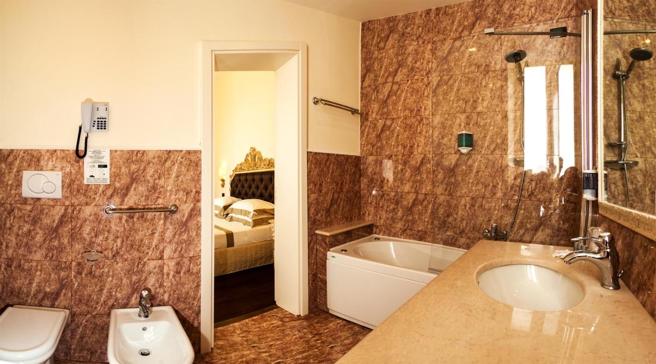 een badkamer met een wastafel, een badkuip en een toilet bij Grand Hotel Di Lecce in Lecce