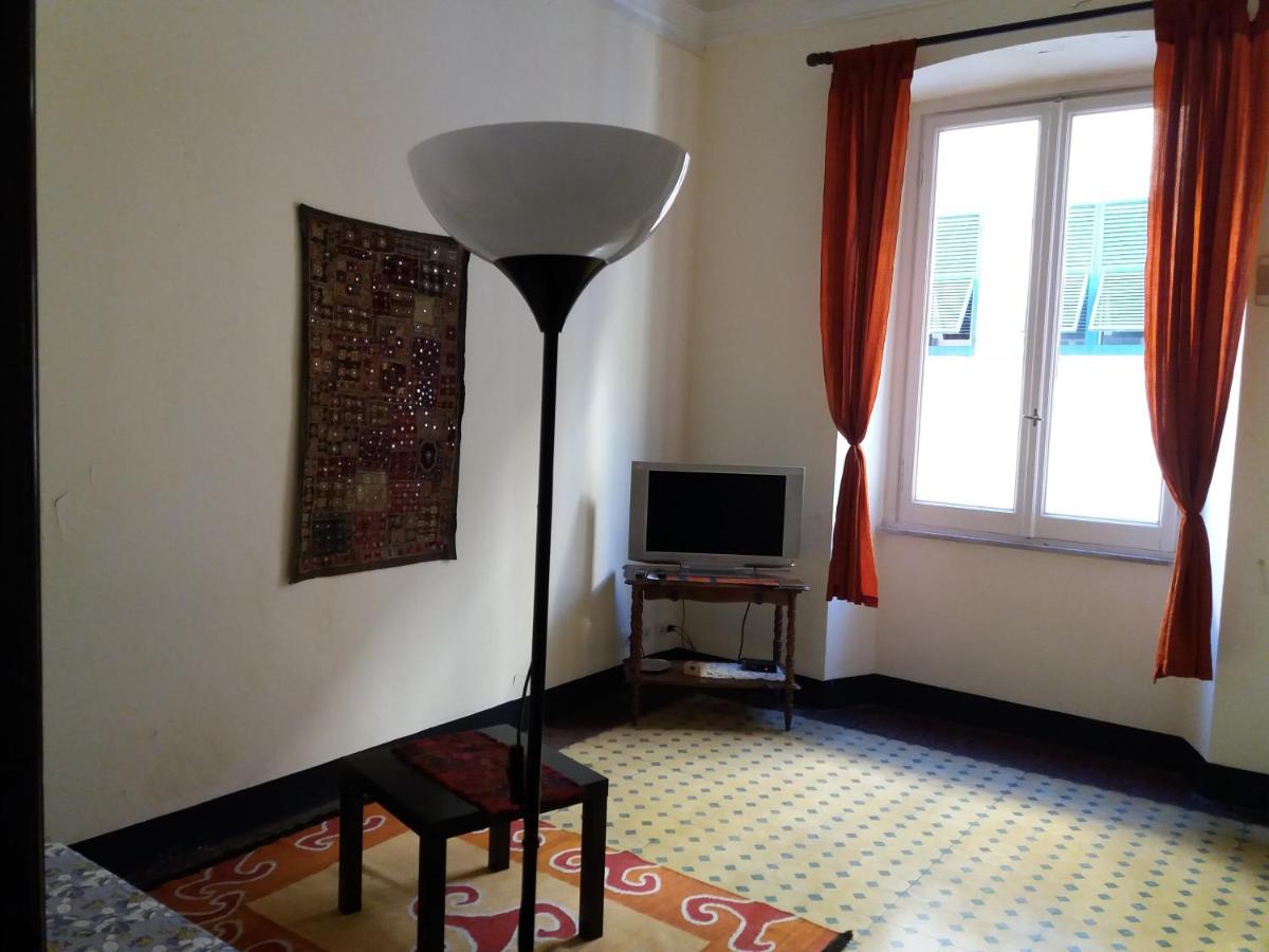 een woonkamer met een staande lamp en een televisie bij Residenza dell'Orto in Chiavari