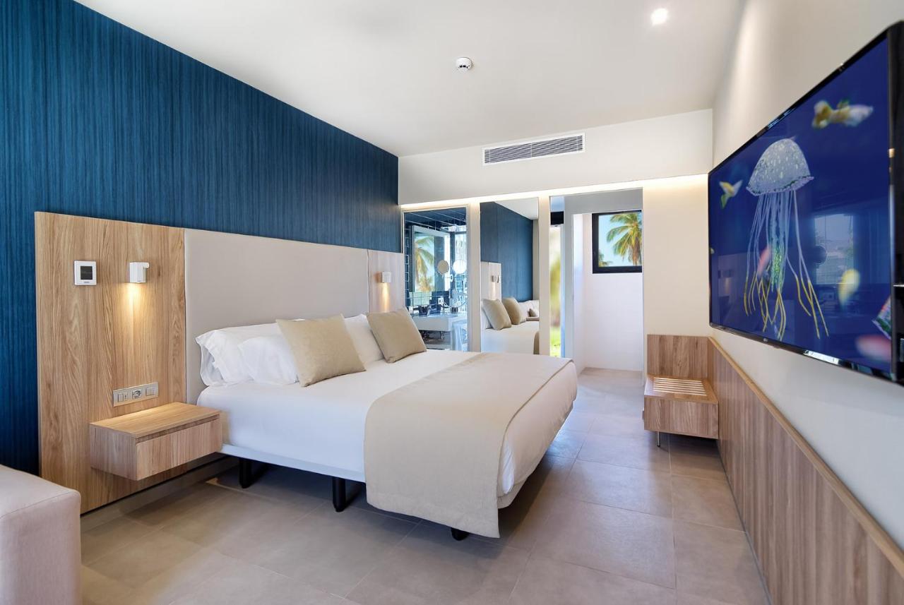 een slaapkamer met een groot bed en een tv bij Club Maspalomas Suites & Spa - Adults Only in Maspalomas