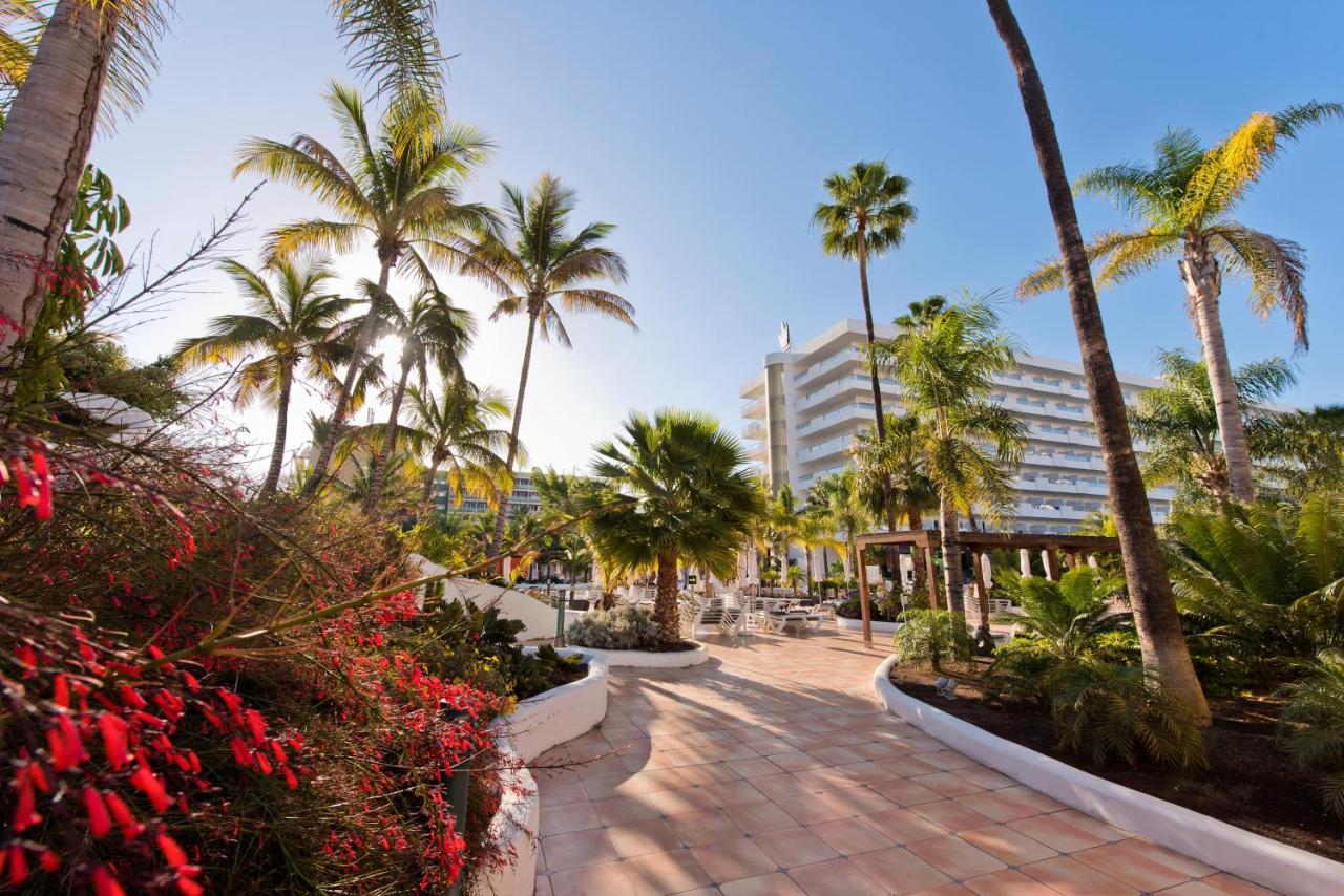 een wandelpad met palmbomen en een gebouw bij Hotel Gran Canaria Princess - Adults Only in Playa del Inglés