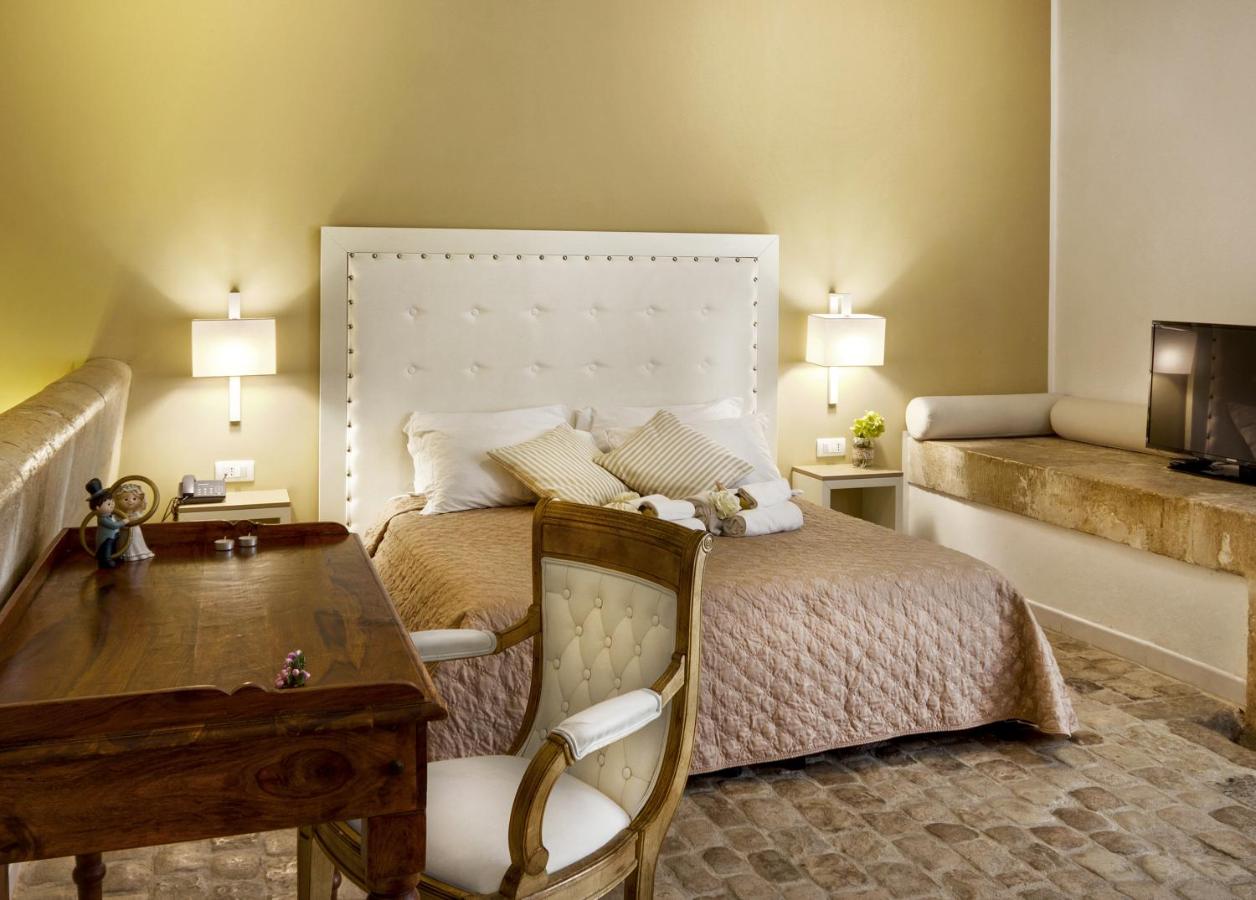 een slaapkamer met een bed, een tafel en een stoel bij Villa Principe Di Belmonte in Ispica