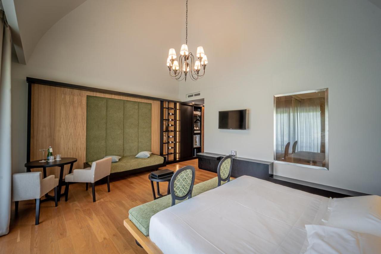 een slaapkamer met een bed, een tafel en stoelen bij Villa Neri Resort & Spa in Linguaglossa
