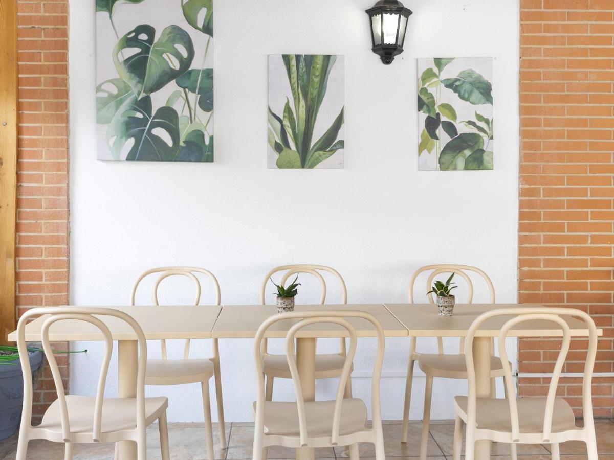 een tafel en stoelen met schilderijen aan de muur bij B&B HOTEL Pomezia Cortese in Pomezia