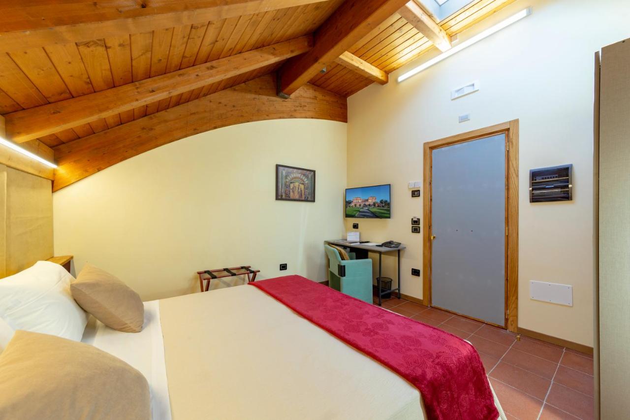 een slaapkamer met een groot bed in een kamer met houten plafonds bij Villa Signorini Hotel in Ercolano