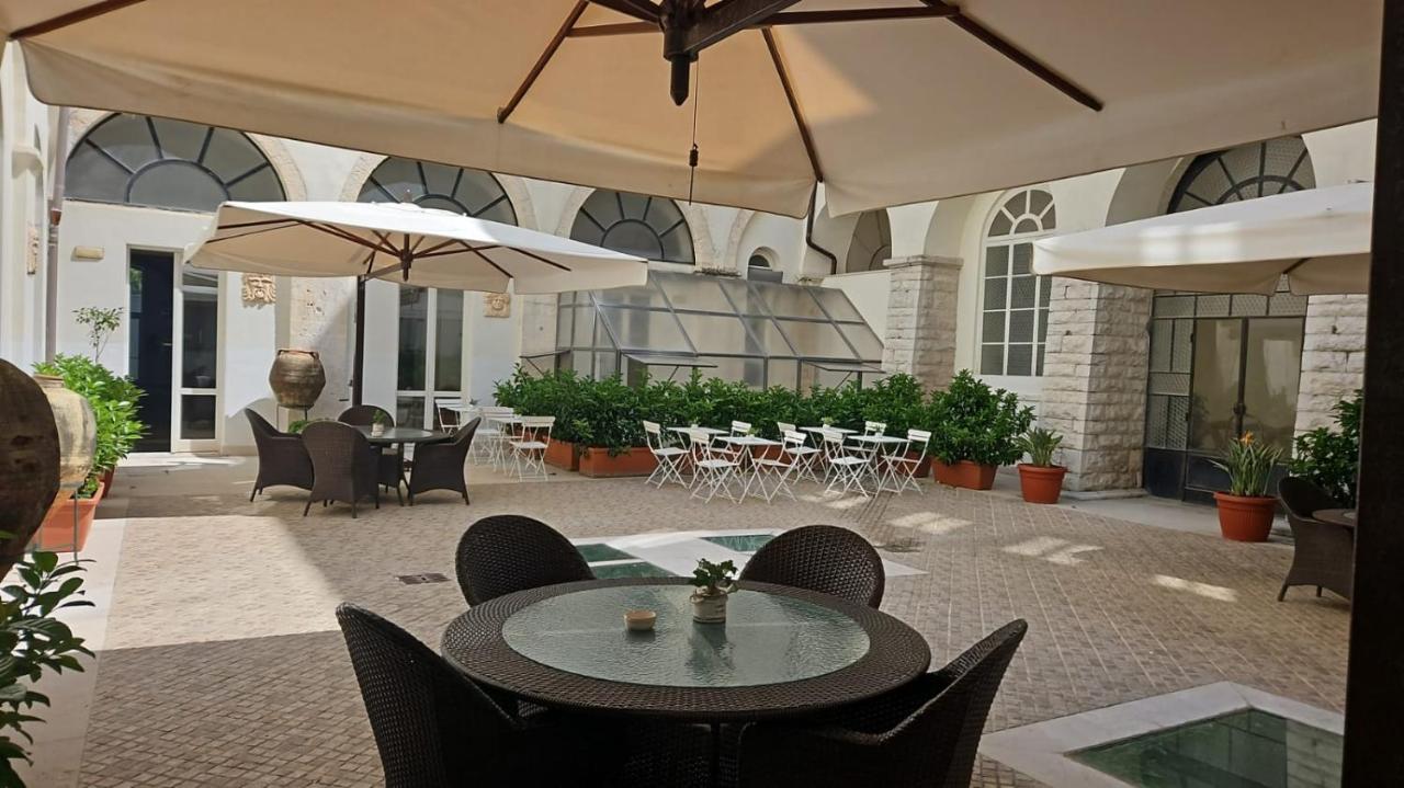 een terras buiten met tafels, stoelen en parasols bij San Paolo Al Convento in Trani