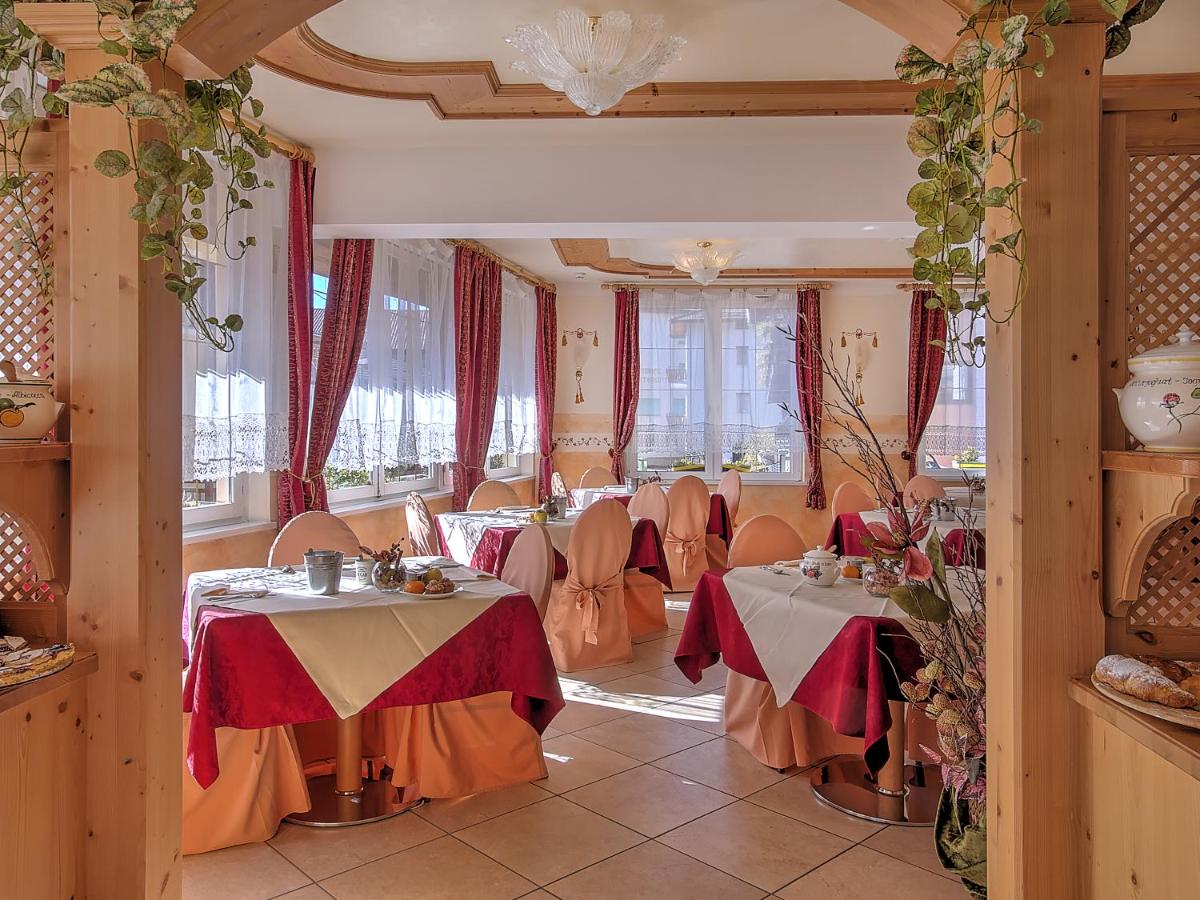 een restaurant met tafels en stoelen in een ruimte bij Al Posta Hotel 1899 in Baselga di Pinè