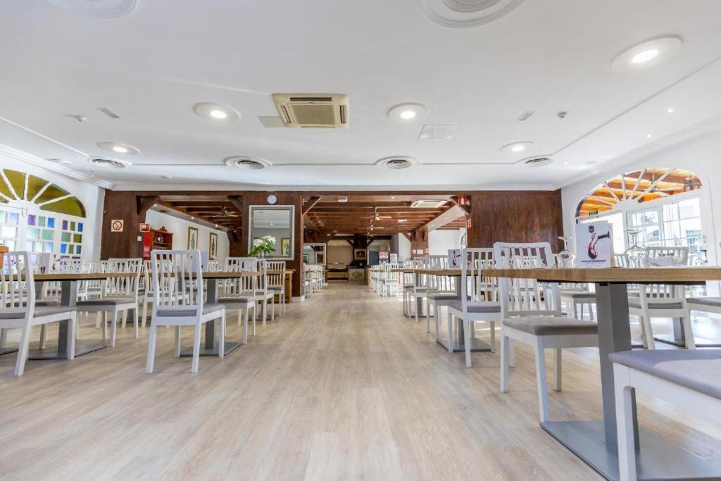 een eetkamer met tafels en witte stoelen bij BLUESEA Rey Carlos in Playa del Inglés