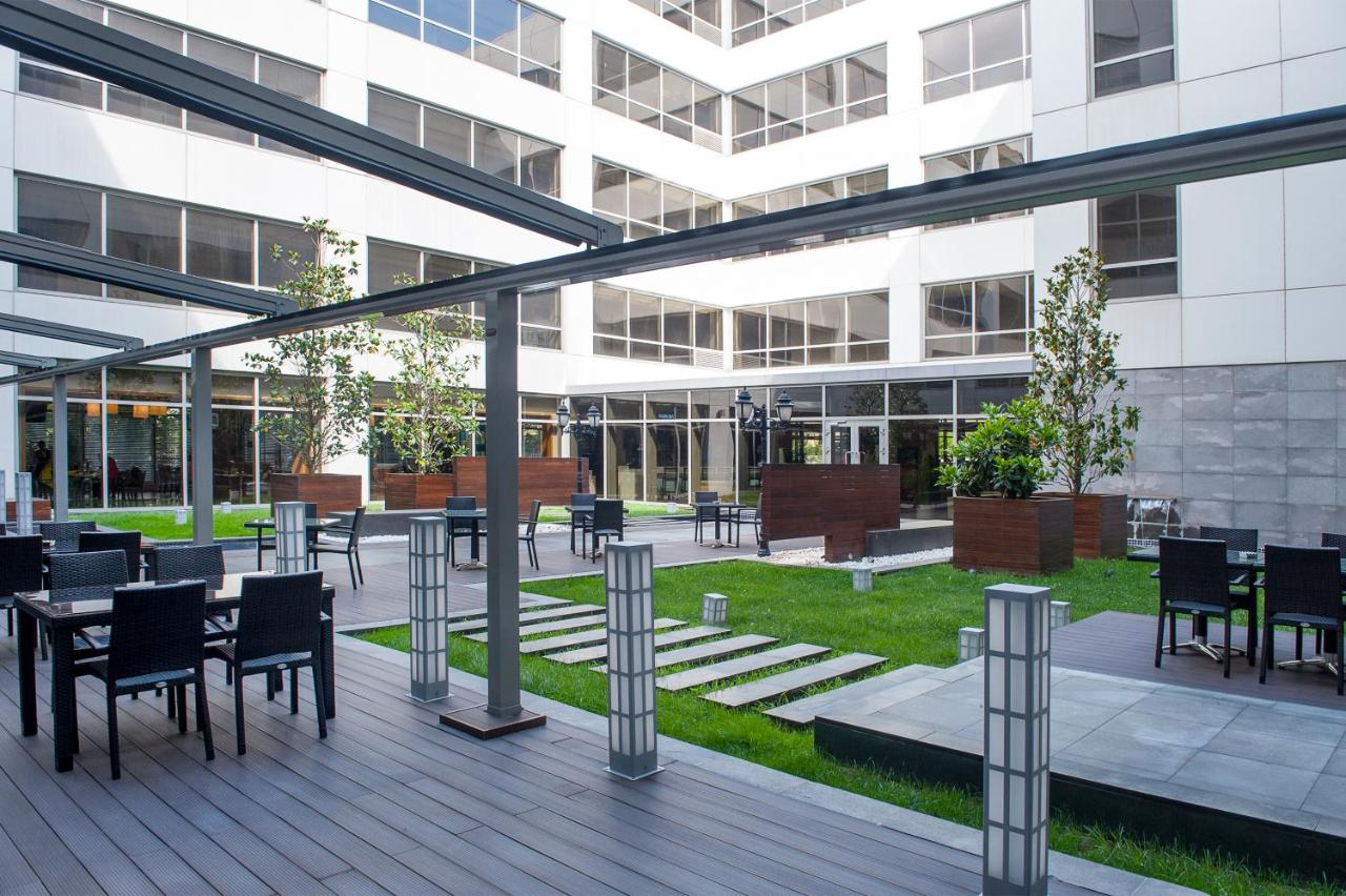 een terras met tafels en stoelen in een gebouw bij ISG Sabiha Gökçen Airport Hotel in Istanbul