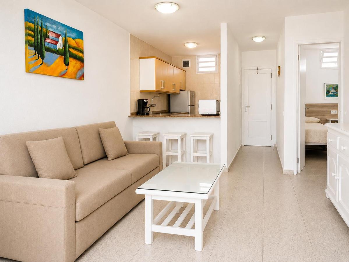een woonkamer met een bank en een tafel bij Apartamentos Tamaragua in Playa del Inglés