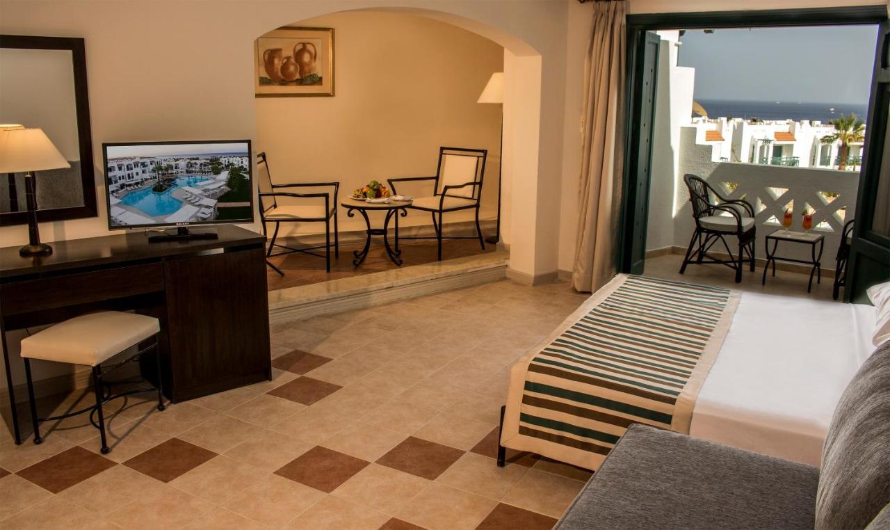 een hotelkamer met een bed, een bureau en een tv bij JAZ Neo Naama Bay in Sharm El Sheikh +27 foto's