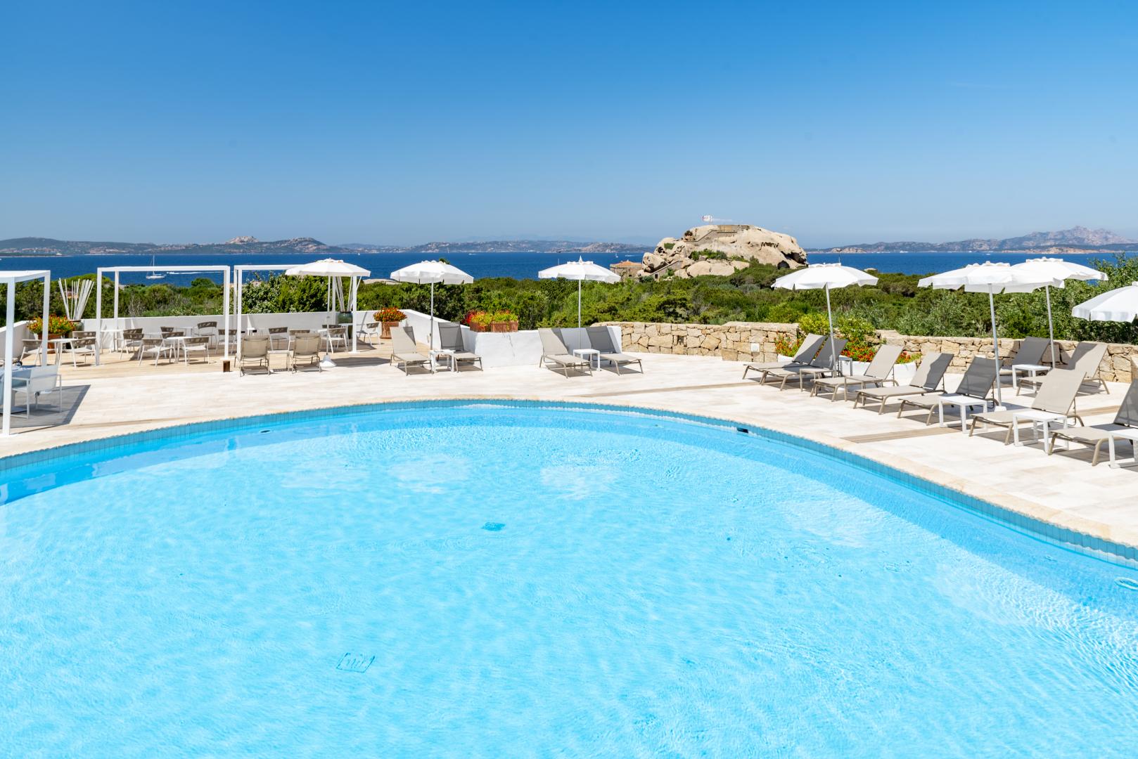 Buitenzwembad met ligbedden — Grand Relais dei Nuraghi