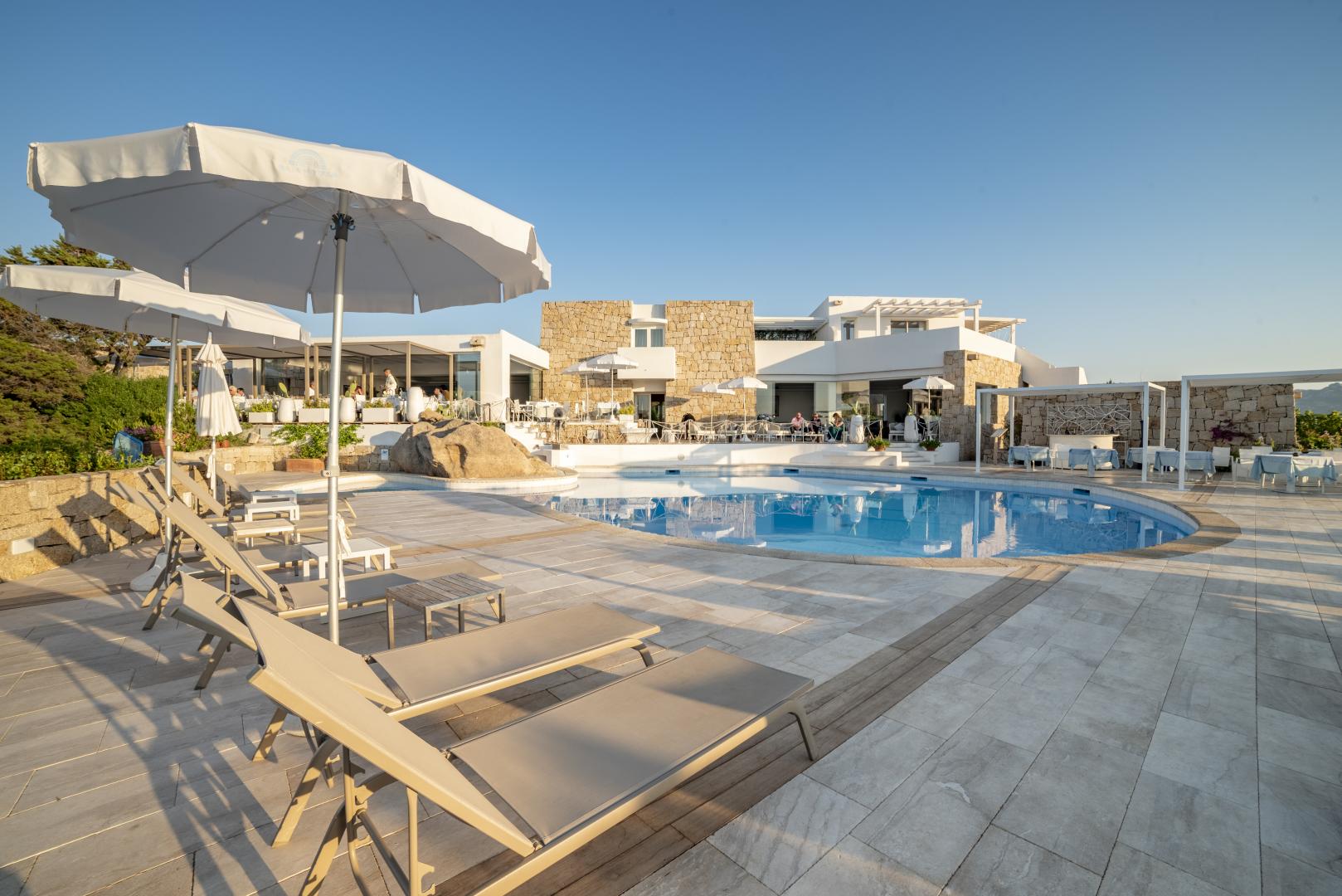 Buitenzwembad met ligbedden — Grand Relais dei Nuraghi