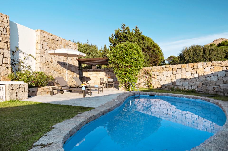 Buitenzwembad met ligbedden — Grand Relais dei Nuraghi