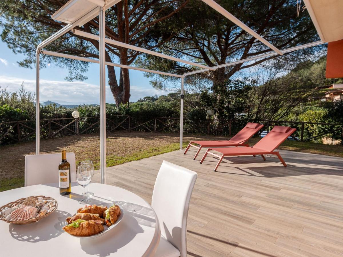een tafel met een bord eten en een fles wijn bij Holiday Home Villa Marzia Mare & Golf by Interhome in Punta Ala