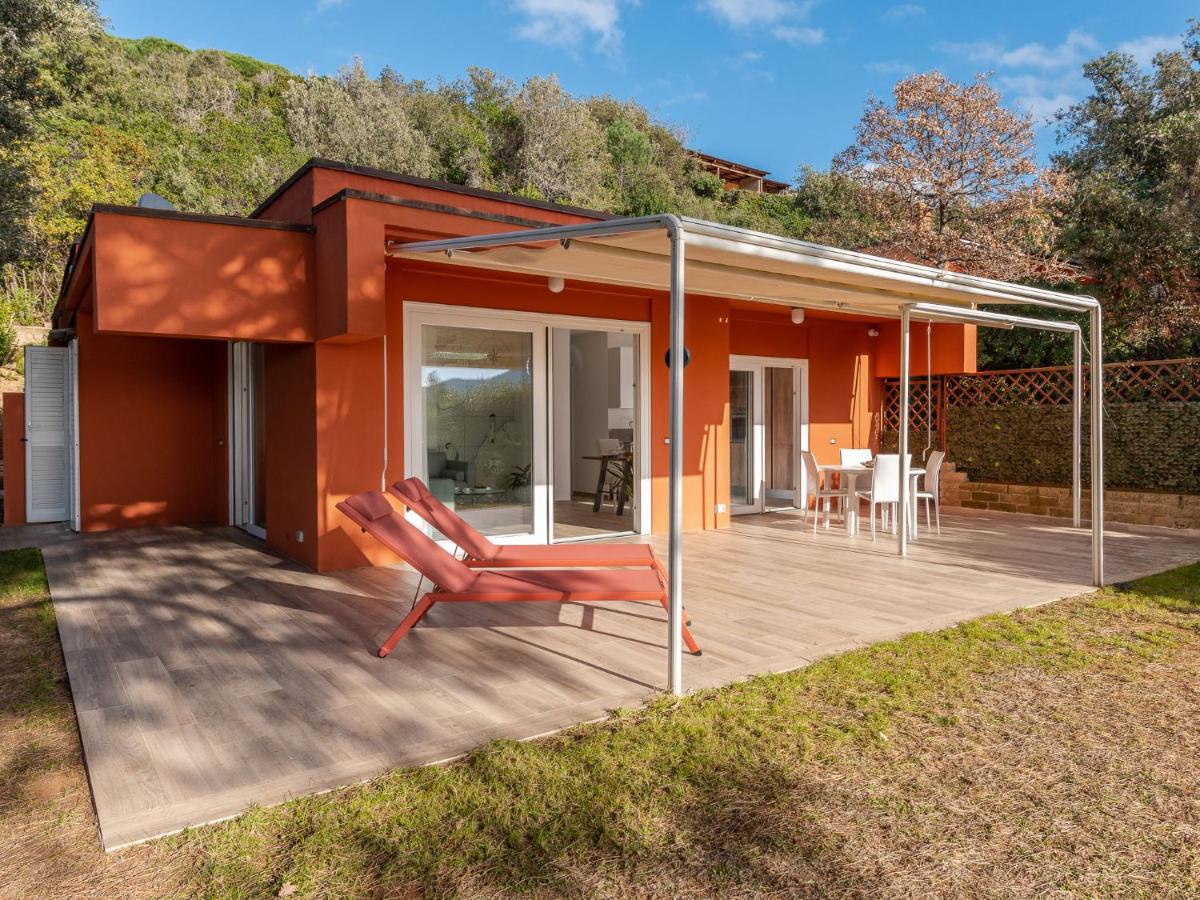 een huis met een terras waarop een stoel staat bij Holiday Home Villa Marzia Mare & Golf by Interhome in Punta Ala
