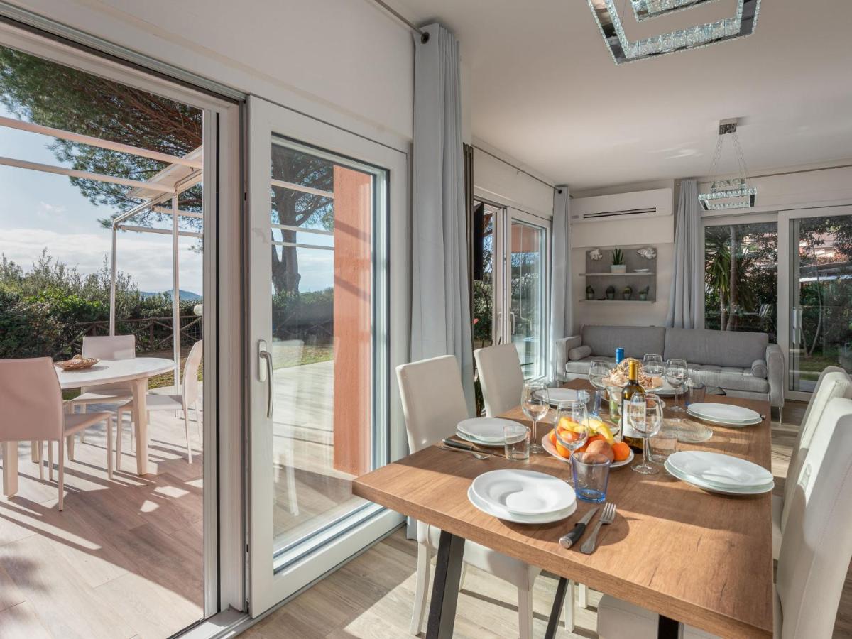 een eetkamer met een tafel en stoelen en schuifdeuren van glas bij Holiday Home Villa Marzia Mare & Golf by Interhome in