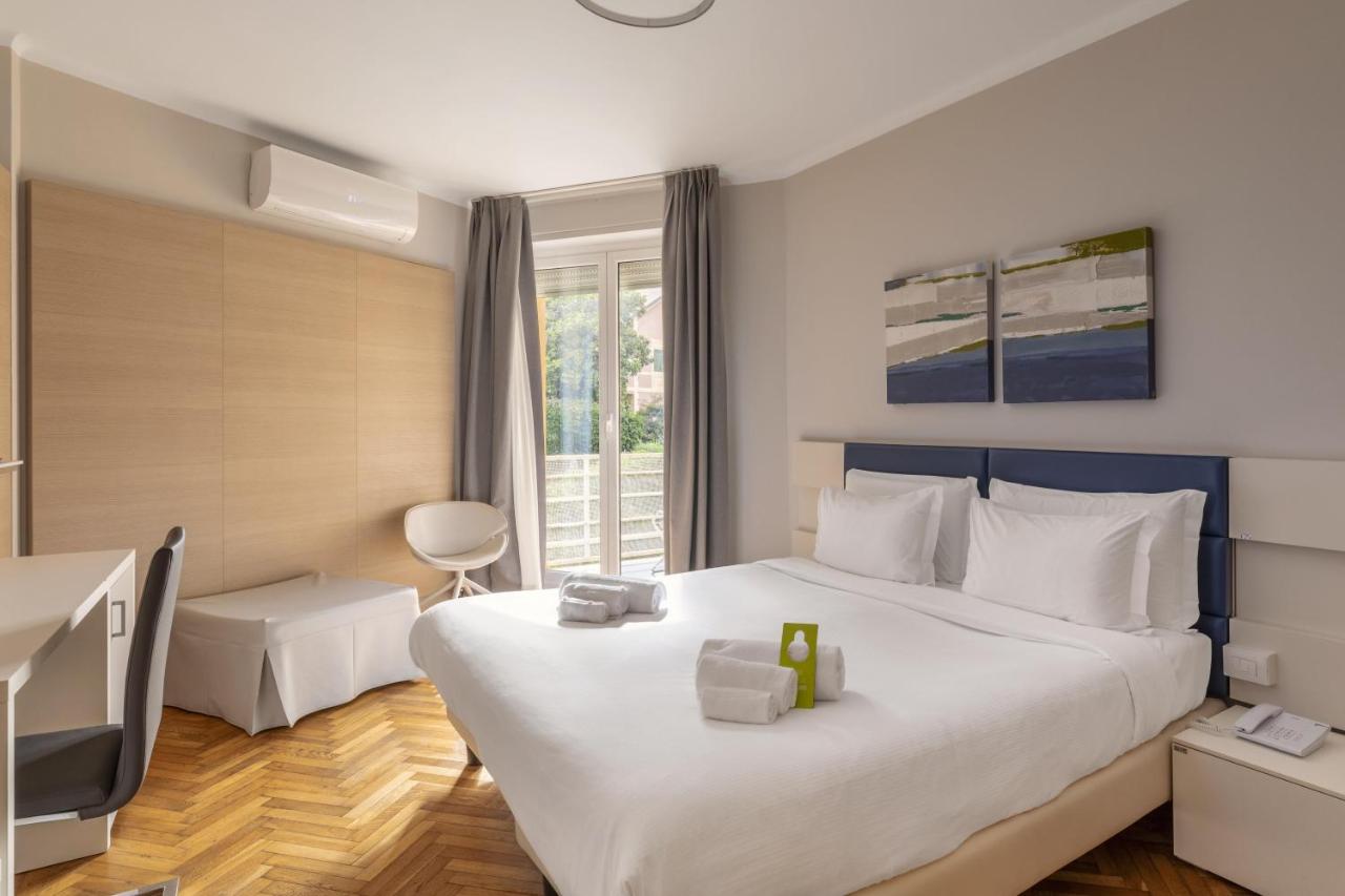 een hotelkamer met een groot bed en een televisie bij B&B Hotels Park Hotel Suisse Santa Margherita Ligure in Santa Marg