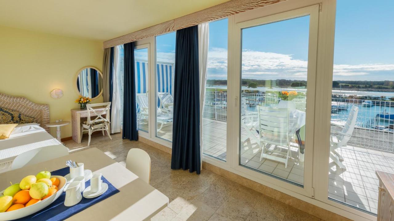 een woonkamer met uitzicht op een balkon bij Hotel Marina Uno in Lignano Sabbiadoro
