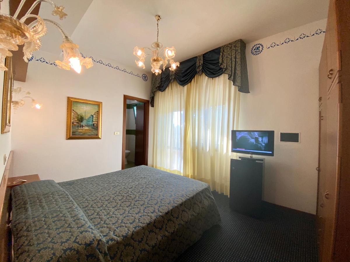 een slaapkamer met een bed en een flatscreen-tv bij Hotel Florida in Lido di Jesolo