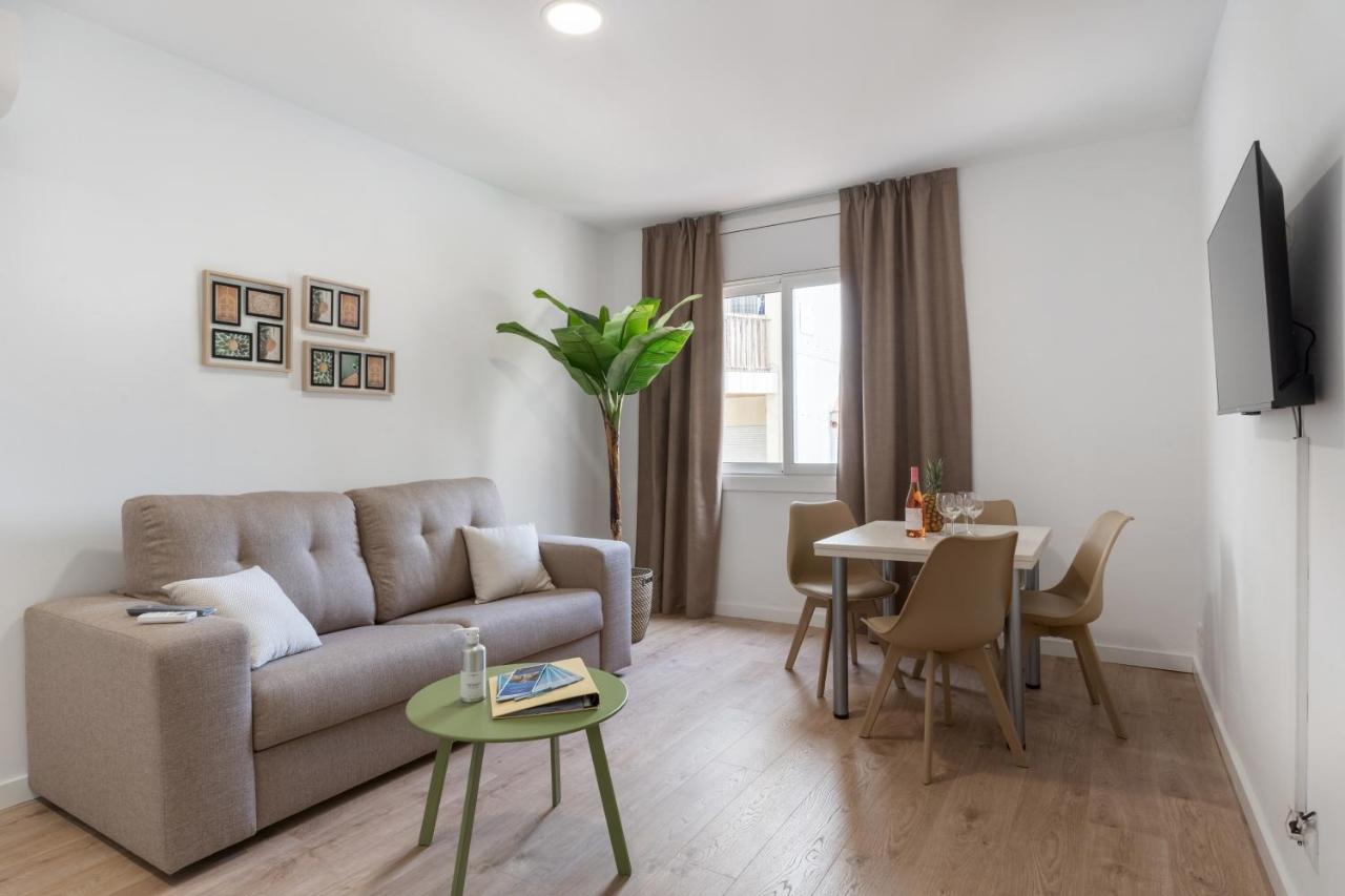 een woonkamer met een bank en een tafel bij Apartamentos Venecia in Lloret de Mar
