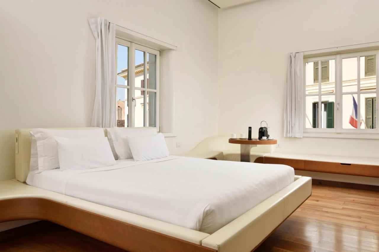 een witte slaapkamer met een groot bed en twee ramen bij Palazzo Montemartini Rome, A Radisson Collection Hotel in Rome