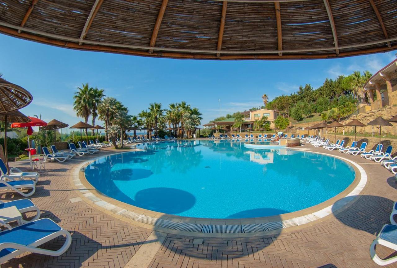 een zwembad bij een resort met ligstoelen bij TH Le Castella - Baia degli Dei Village in Le Castella