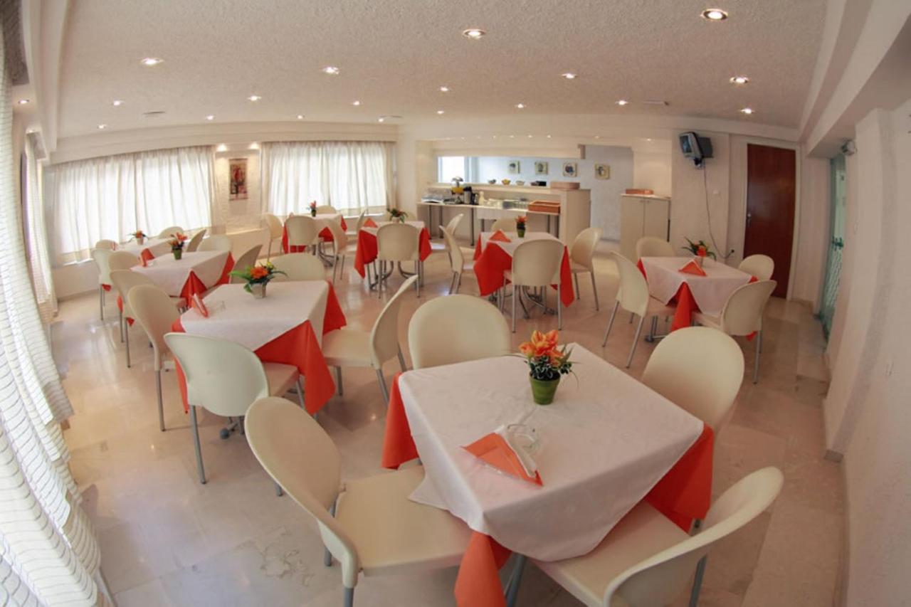 een eetkamer met witte tafels en witte stoelen bij Nancy Hotel in Chersonissos