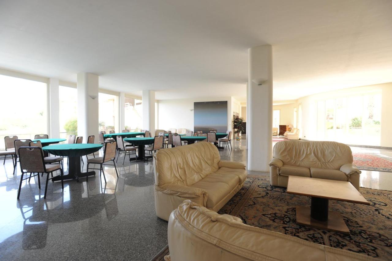 een woonkamer met banken, tafels en stoelen bij Hotel President in Marsala