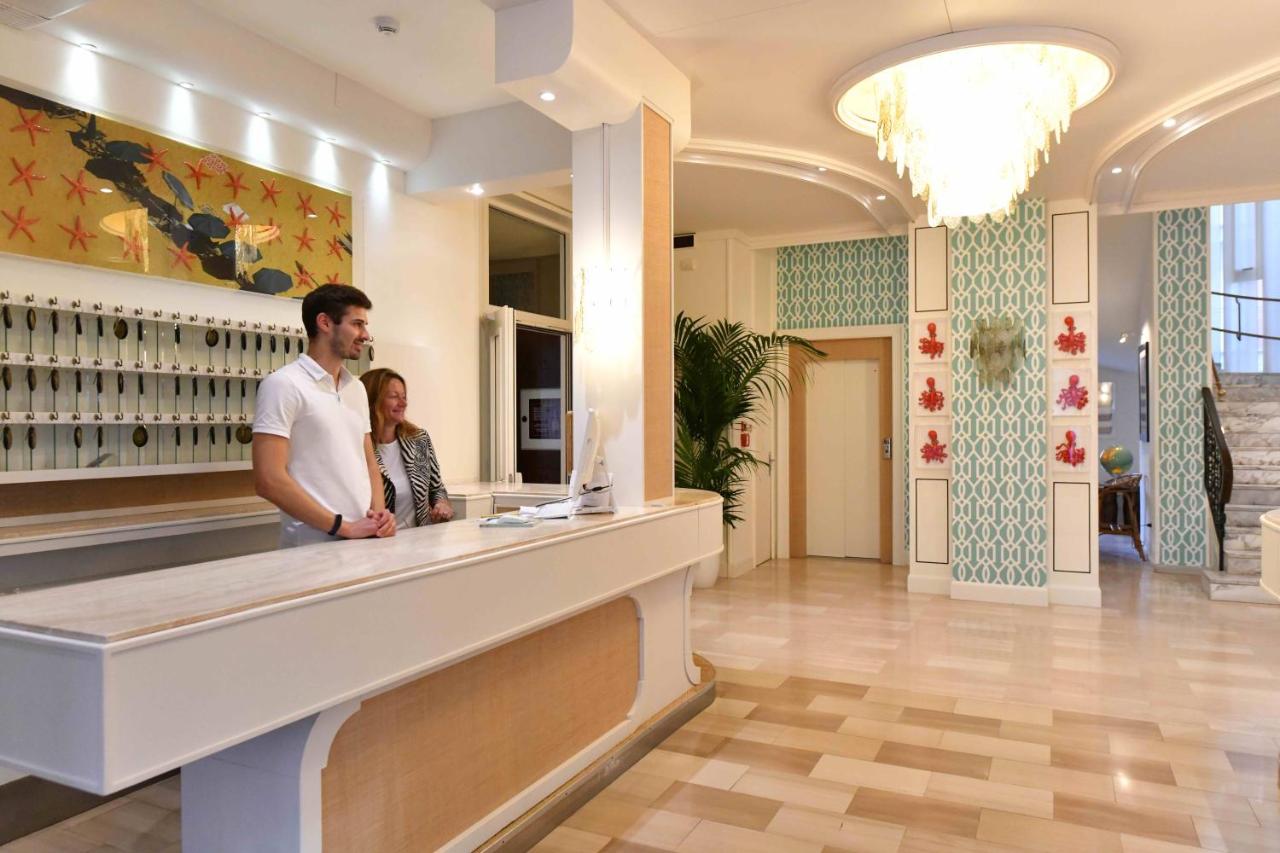 een man en een vrouw staan bij een toonbank in een winkel bij Hotel Majestic in Lido di Jesolo