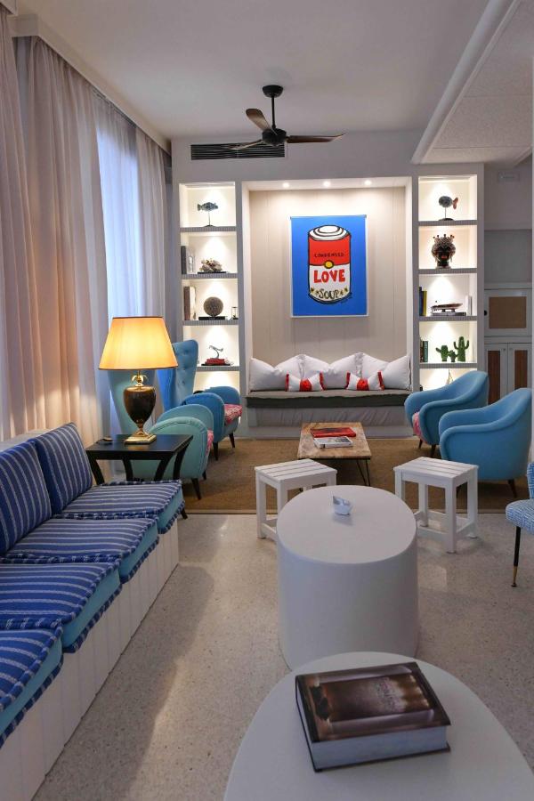 een woonkamer met een bank, stoelen en tafels bij Hotel Majestic in Lido di Jesolo