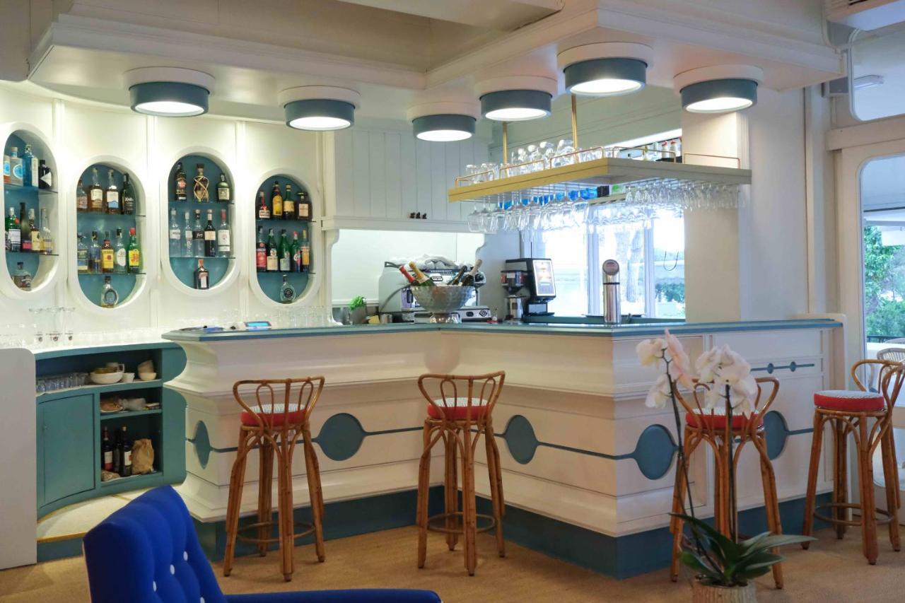 een bar met stoelen en een toonbank met flessen wijn bij Hotel Majestic in Lido di Jesolo
