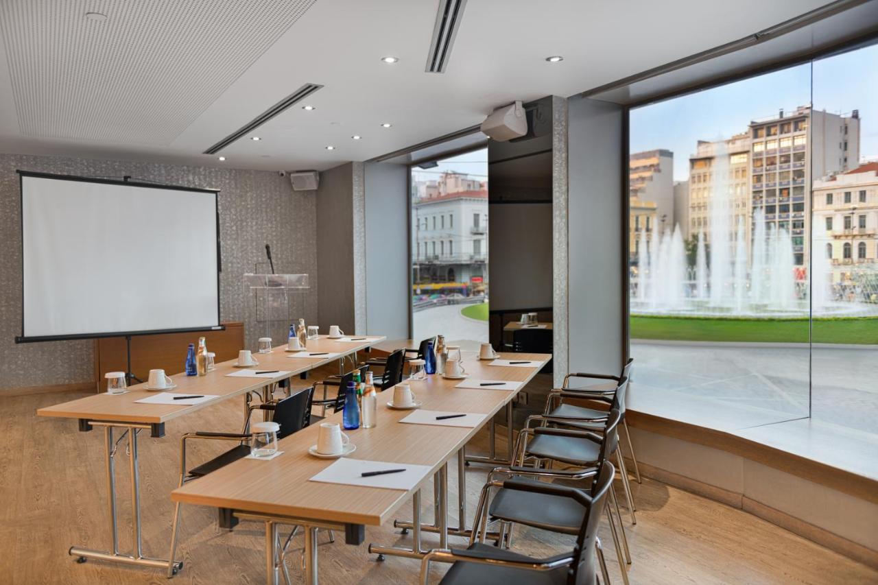 een vergaderruimte met tafels en stoelen en een projectiescherm bij Athens Tiare by Mage Hotels in Athene