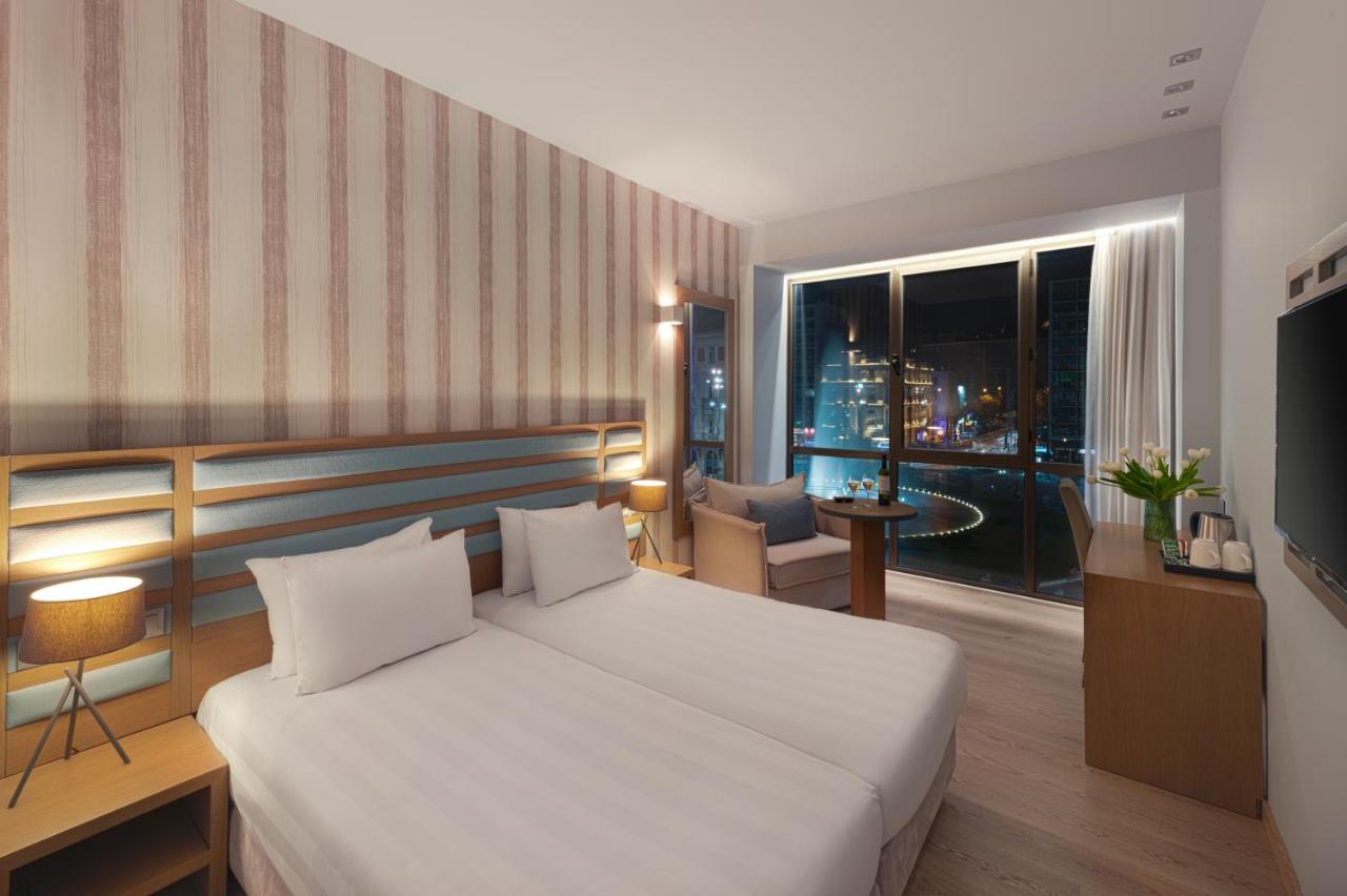 een slaapkamer met een wit bed en een groot raam bij Athens Tiare by Mage Hotels in Athene