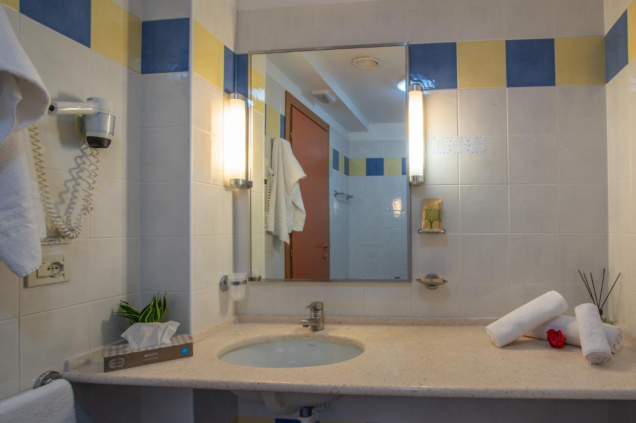 een badkamer met een wastafel en een spiegel bij Hotel Rialto in Grado