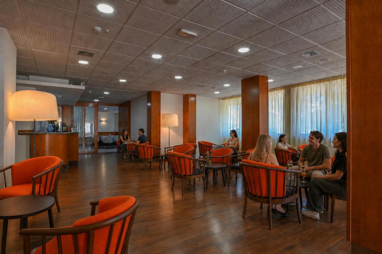 een groep mensen die aan tafels in een restaurant zitten bij Hotel Rialto in Grado
