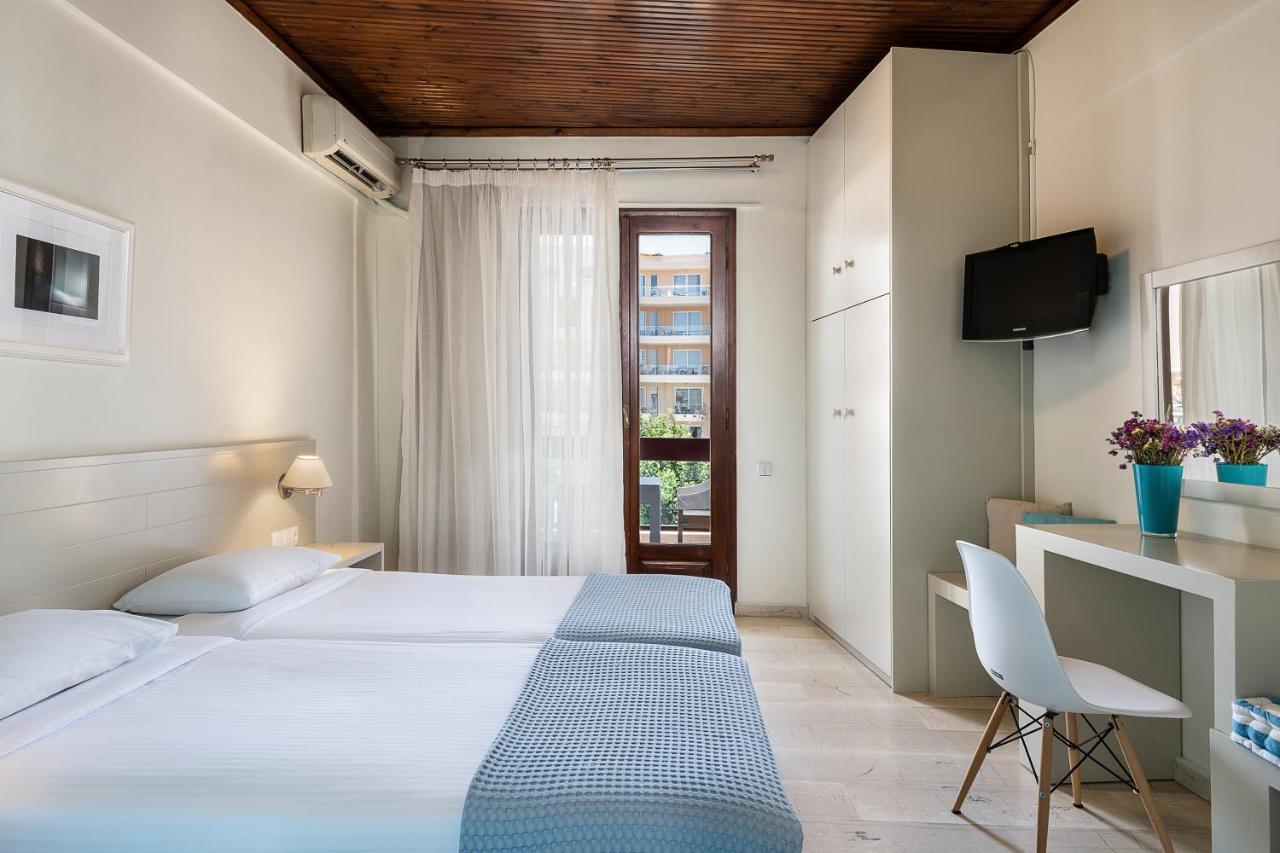 een slaapkamer met een bed, een bureau en een televisie bij Magia Apartments in Chania