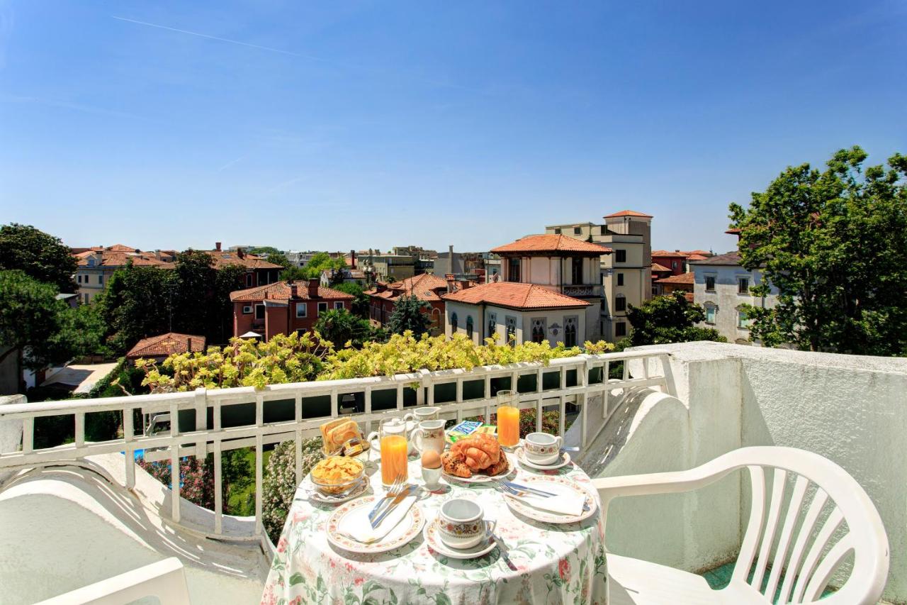 een tafel met eten en drinken op een balkon bij Hotel Biasutti in Venetië-Lido