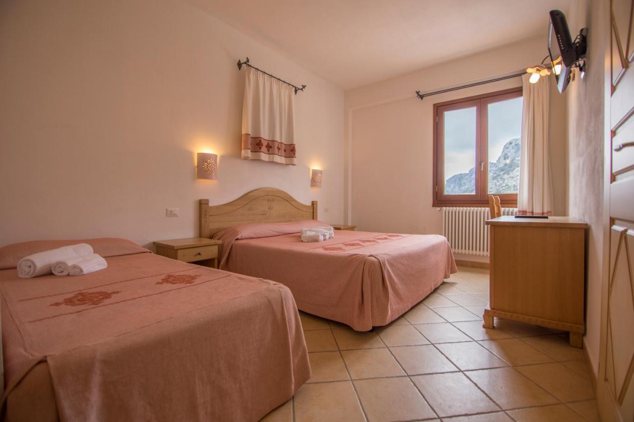 een hotelkamer met twee bedden en een raam bij Gorropu Hotel in Urzulei