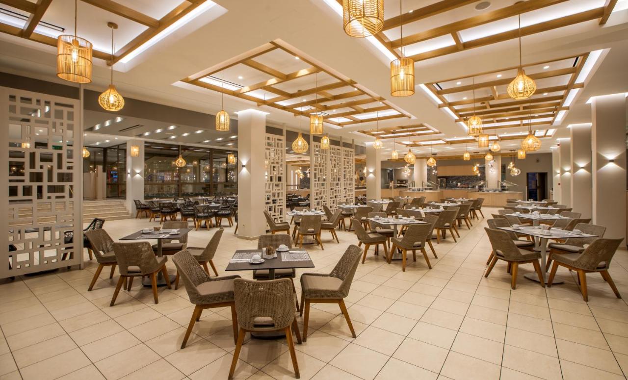 een eetkamer met tafels, stoelen en verlichting bij Porto Bello Royal in Kardamaina
