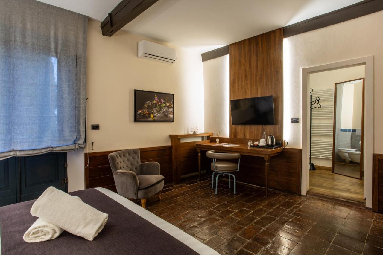 een hotelkamer met een bureau en een bed bij La Loggia Historic Resort - Albergo Diffuso in Gradara
