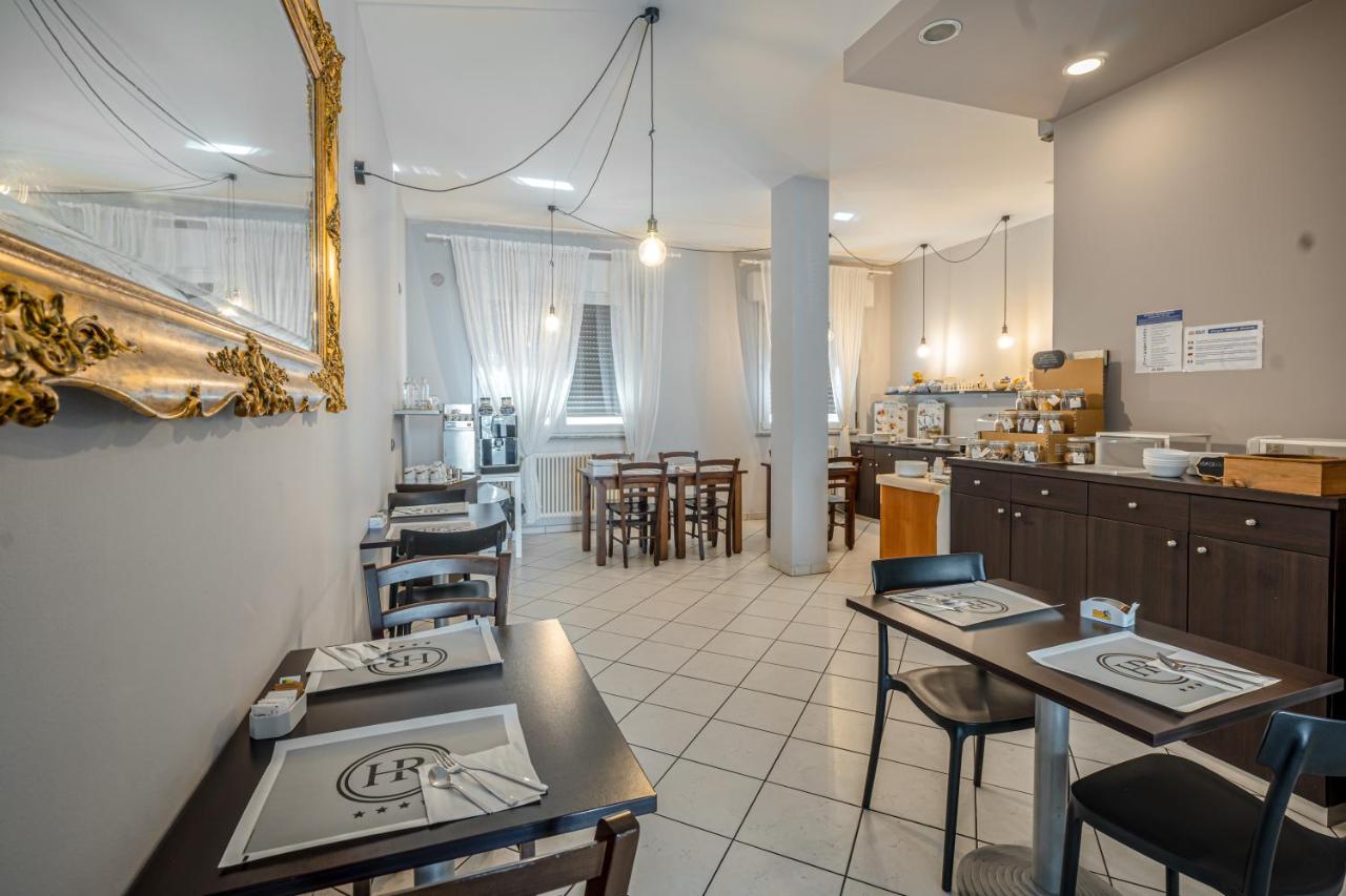 een restaurant met tafels en stoelen en een keuken bij Hotel Rubicone in Savignano sul Rubicone